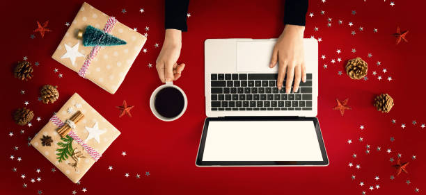 istock Christmas ornaments with person using a laptop computer 1192999546