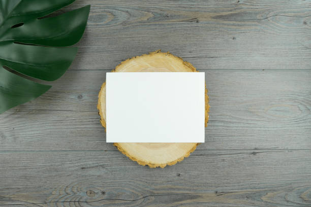 istock Flat lay plain natural wood background with a plain white 5x7 paper template that can be used for invitation, products, wedding, logo or flyer. 1193010701