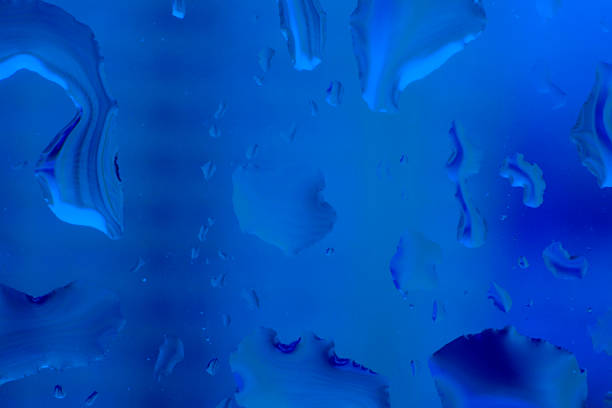 istock Abstract water drops on glass. defocused background. Horizontal. Rainy day View through the window. Classic, blue monochrome, trend 2020 1193012823