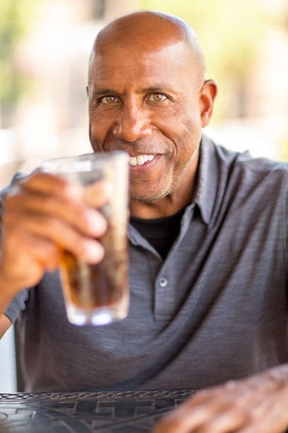 Portrait of an African American man at a restaurant having a drink.