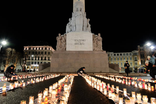 o 78º aniversário da destruição por nazistas alemães e colaboradores letões dos prisioneiros do gueto de riga. estátua da liberdade - milda em latvia. - riga baltic countries europe night - fotografias e filmes do acervo