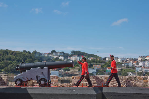 Guards Firing The Noon Day Gun At Castle Cornet, St. Peter Port, Guernsey, Channel Islands ST. PETER PORT, GUERNSEY, UK - AUGUST 16, 2017: Guards Firing The Noon Day Gun At Castle Cornet, St. Peter Port, Guernsey, Channel Islands. guernsey city stock pictures, royalty-free photos & images