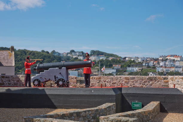 Guards Firing The Noon Day Gun At Castle Cornet, St. Peter Port, Guernsey, Channel Islands ST. PETER PORT, GUERNSEY, UK - AUGUST 16, 2017: Guards Firing The Noon Day Gun At Castle Cornet, St. Peter Port, Guernsey, Channel Islands. guernsey city stock pictures, royalty-free photos & images