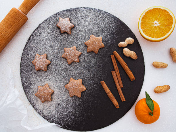 biscuits de sucre faits maison de sablé de noel de forme d'étoile avec la poudre de sucre, la cannelle, le sapin vert et le biscuit. cuisson de noel. vu d'en haut. biscuits végétaliens - cookie christmas shortbread christmas tree photos et images de collection