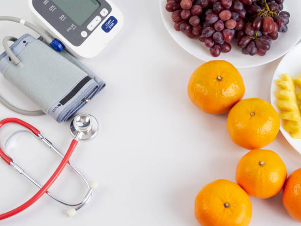 stetoscopio medico con monitor automatico della pressione sanguigna e frutta su sfondo bianco. giornata mondiale della salute. - 5487 foto e immagini stock