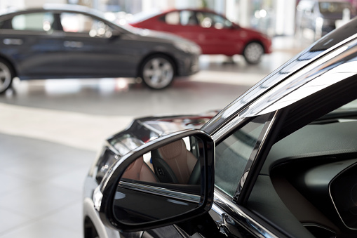 New cars at dealer showroom. Themed blur background with bokeh effect. Car auto dealership. Prestigious vehicles.