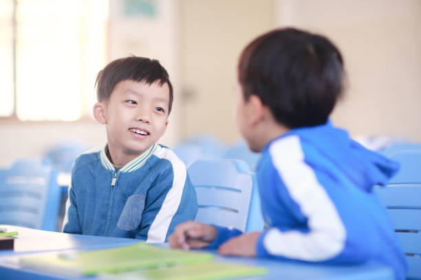 istock Young boy reading at his desk in a classroom 1193028261