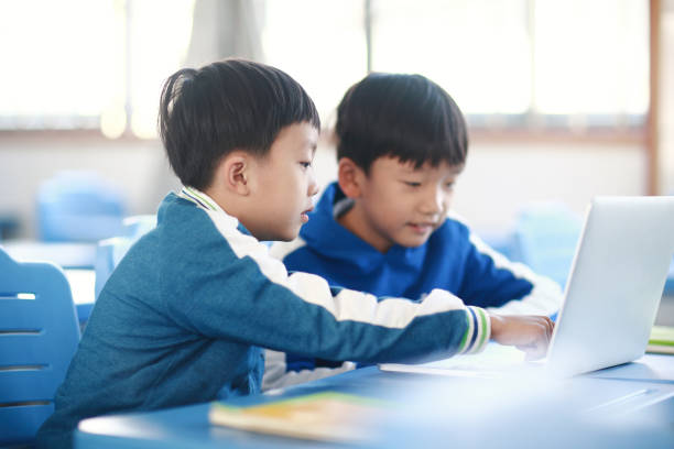 istock Young boy reading at his desk in a classroom 1193028299