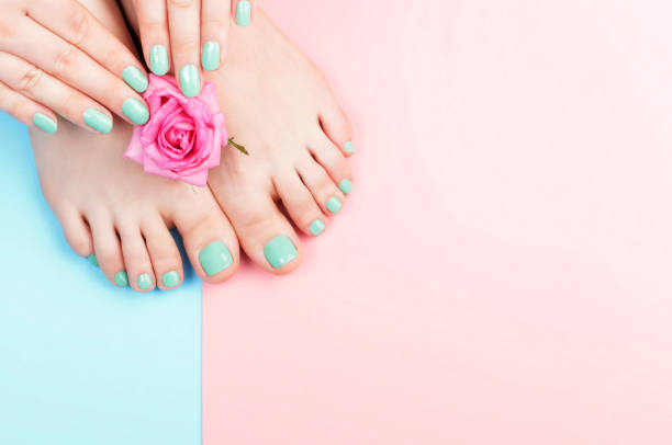 女性の手、マニキュアとペディキュアとピンク、青の背景、トップビューに花を持つペディキュア - soft gel ストックフォトと画像