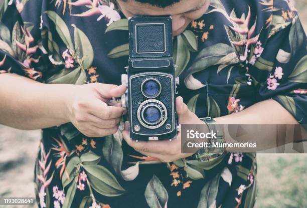 Man Rotating Vintage Film Camera With Looking Stock Photo - Download Image Now - Hawaii Islands, Movie, Film Industry