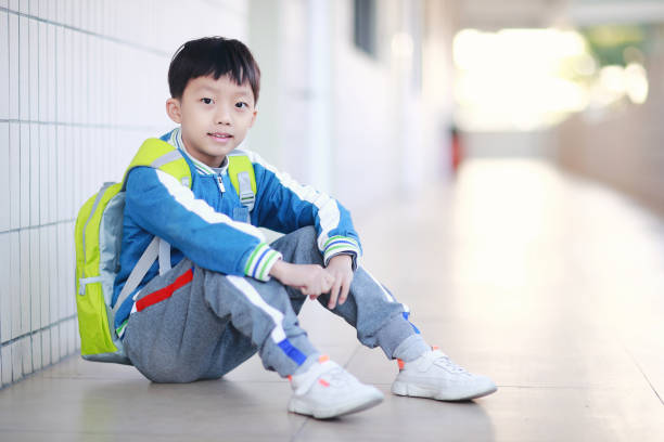 istock Young boy reading at his desk in a classroom 1193029583