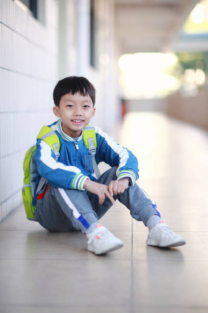 istock Young boy reading at his desk in a classroom 1193029591