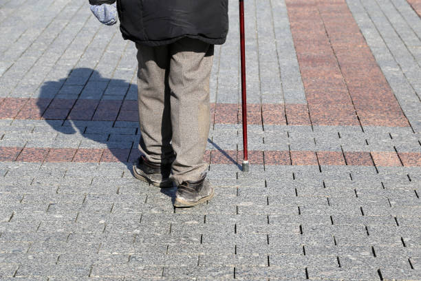 istock Man walking with a cane down the street 1193031646