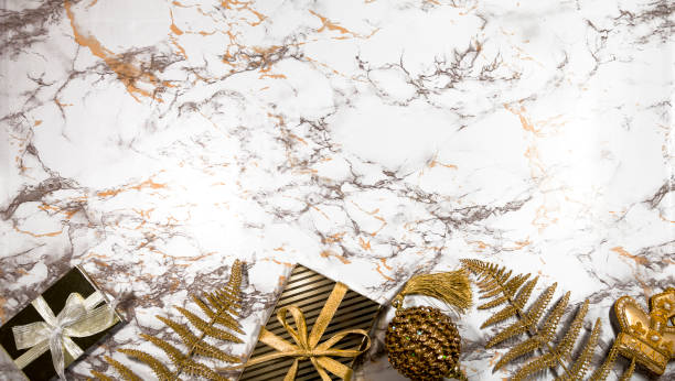 Christmas composition - gold gifts, Xmas bauble, fern foliage, balls on marble background with stars, lights. Creative banner new Year greeting card in trend colors. Flat lay, top view, copy space composición de navidad - regalos de oro, navidad bauble, follaje de helecho, bolas sobre fondo de mármol con estrellas, luces. bandera creativa tarjeta de felicitación de año nuevo en colores de tendencia. plano, vista superior, espacio de copia