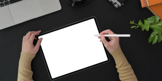 istock Top view of young woman working on her project with blank screen tablet 1193034176