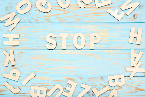 istock Word Stop by wooden letters on blue table 1193034480