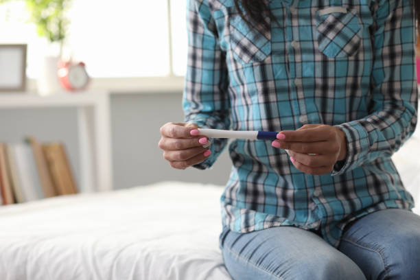 istock A lonely woman sits on bed and holds pregnancy test 1193036983