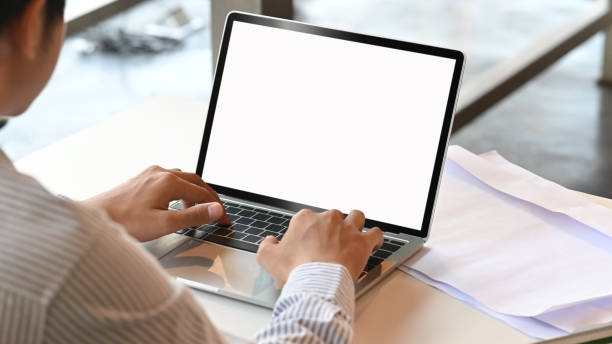Cropped shot man typing mockup laptop computer with blank screen. stock photo