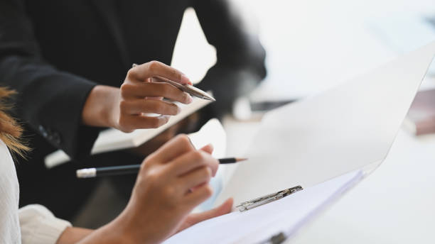 istock Closeup two woman consulting with paperwork document report. 1193042721