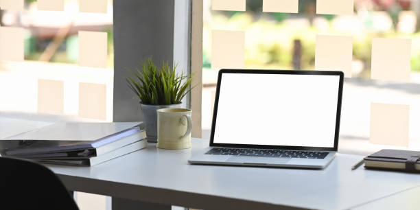 istock Workspace desk with Mockup Laptop with blank screen and coffee mug, notebook with document paper in office table. 1193044180