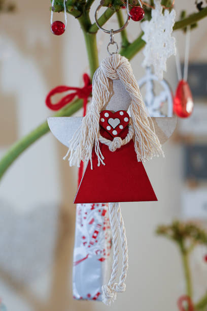 Wooden hand holding Christmas ornament isolated on white background