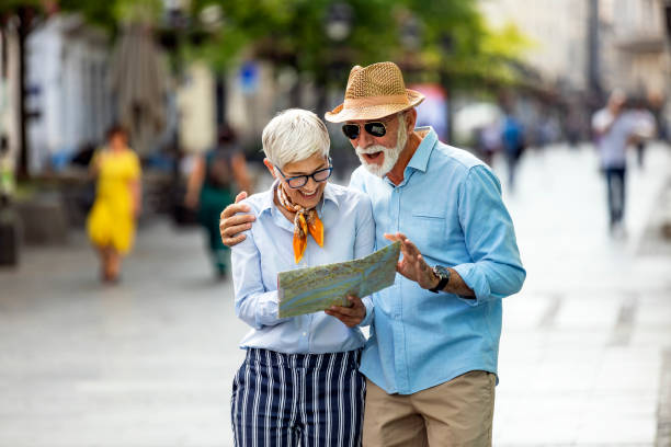 istock Active Senior Tourists are Walking Through the City Streets with Map 1193045024