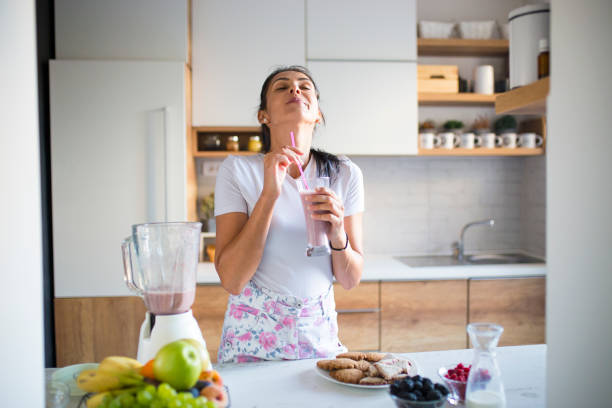 istock Smiling woman drinking smoothie 1193045345