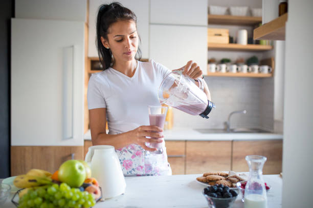 istock Smiling woman making smoothie 1193046103