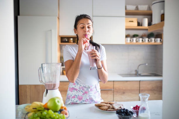 istock Smiling woman drinking smoothie 1193046356