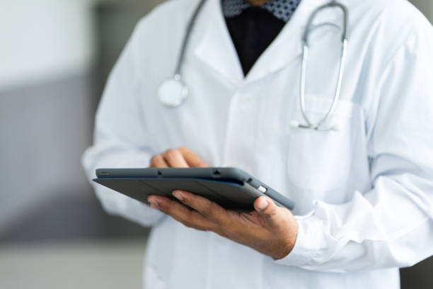 Close up of a doctor checking patient information via tablet. stock photo