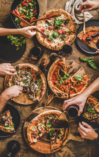istock People having pizza dinner party with red wine, top view 1193046572
