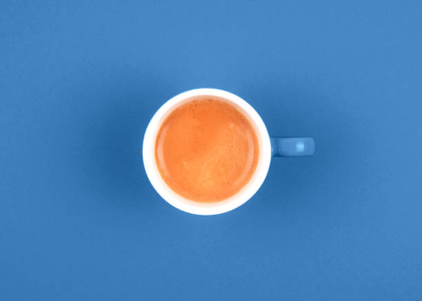 istock Fresh brewed coffee in ceramic orange cup over  blue background. 1193047710