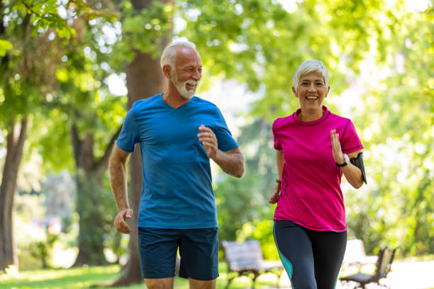 istock Active Senior Couple is Jogging Outdoors in Nature 1193048875