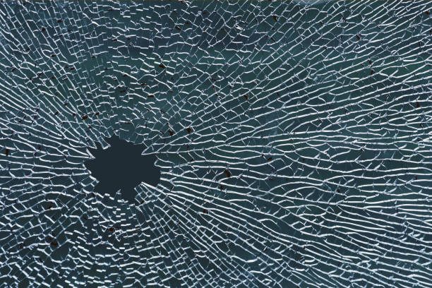 壊れた強化ガラス、窓ガラスまたは車のフロントガラスの穴 - bullet hole glass cracked hole ストックフォトと画像