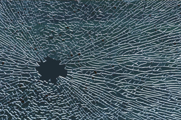 vidro temperado quebrado, um furo no vidro de janela ou no pára-brisa do carro - bullet hole hole glass destruction - fotografias e filmes do acervo