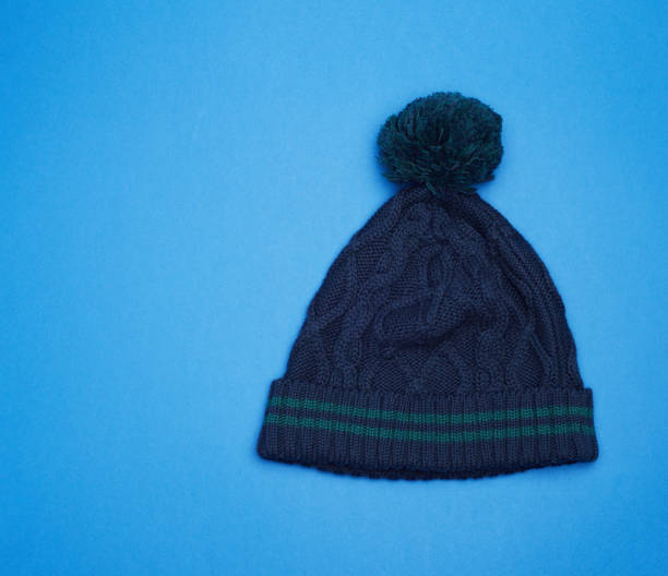 istock dark blue knitted hat with pompom on a blue background 1193050129