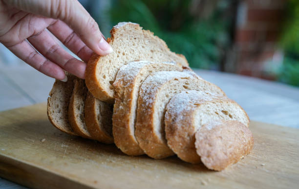 istock Hand picking a slice of sourdough bread from a loaf 1193050978