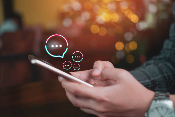istock People hand using smartphone typing, chatting or text  messages in chat icons pop up. Social media maketing technology concept. Vintage soft color tone background. 1193054785