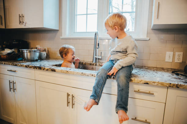 istock Brother and Sister playing at the Kitchen Sink 1193055487