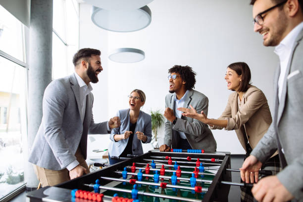 istock Happy young office workers playing table football 1193062529