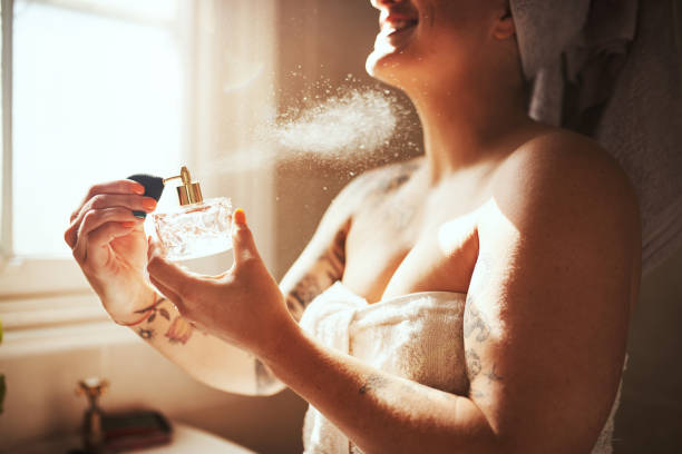 Smells like it's going to be a beautiful day Cropped shot of a young woman spraying perfume during her morning beauty routine body odor stock pictures, royalty-free photos & images