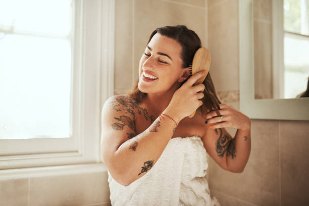 Love your hair and it'll love you back Shot of an attractive young woman brushing her hair during her morning beauty routine at home brushing hair stock pictures, royalty-free photos & images