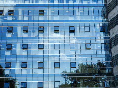 Glass blue square Windows of facade modern city business building skyscraper. Modern apartment buildings in new neighborhood. Windows of a building, texture
