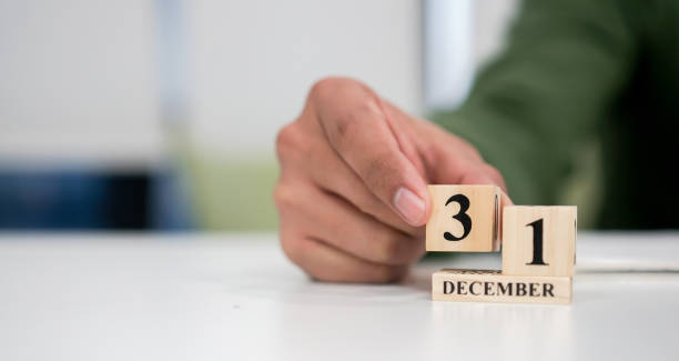 close up employee man hand put number 3 of cube shape wood to make calendar date December 31 at office desk for the last day of the last year countdown concept close up employee man hand put number 3 of cube shape wood to make calendar date December 31 at office desk for the last day of the last year countdown concept number 31 stock pictures, royalty-free photos & images