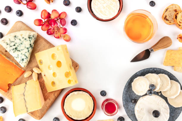 istock Cheese, a flat lay top shot on a white background with copy space. Blue cheese, Leicester, Emmental, Brie, and others sorts with wine, fruits, nuts, forming a frame with a place for text 1193064398