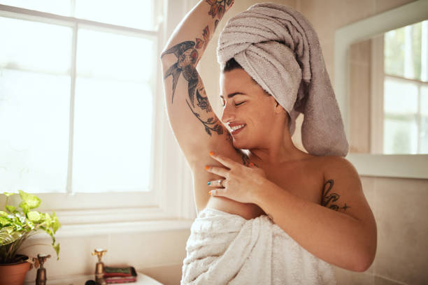 No hair, no problem Shot of an attractive young woman feeling her armpits during her morning beauty routine deodorant stock pictures, royalty-free photos & images