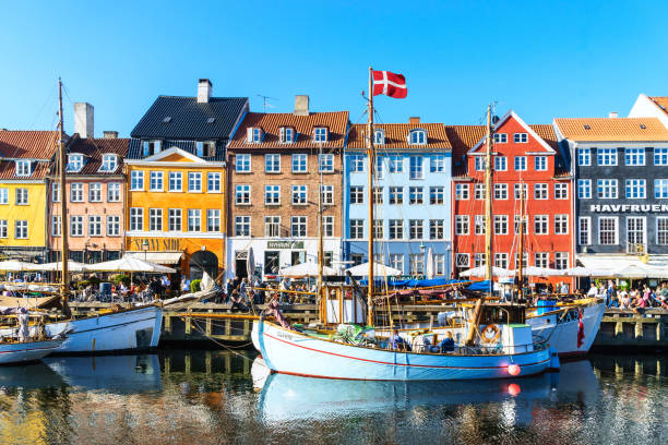 Copenhagen Nyhavn panorama city crowds enjoying sunshine restaurants bars Denmark stock photo