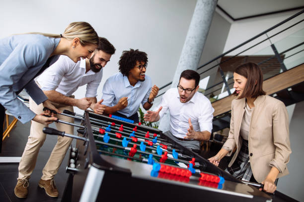 istock Happy young office workers playing table football 1193065542