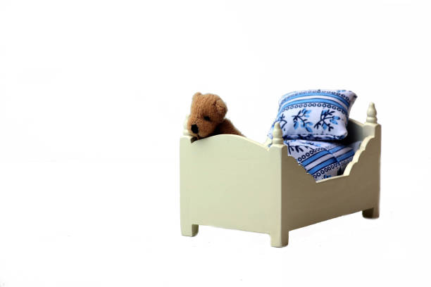 istock Teddy bear on a bed isolated on white background 1193066280