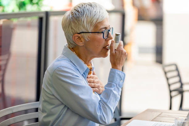 istock Mature Business Woman Using Asthma Inhaler 1193066339
